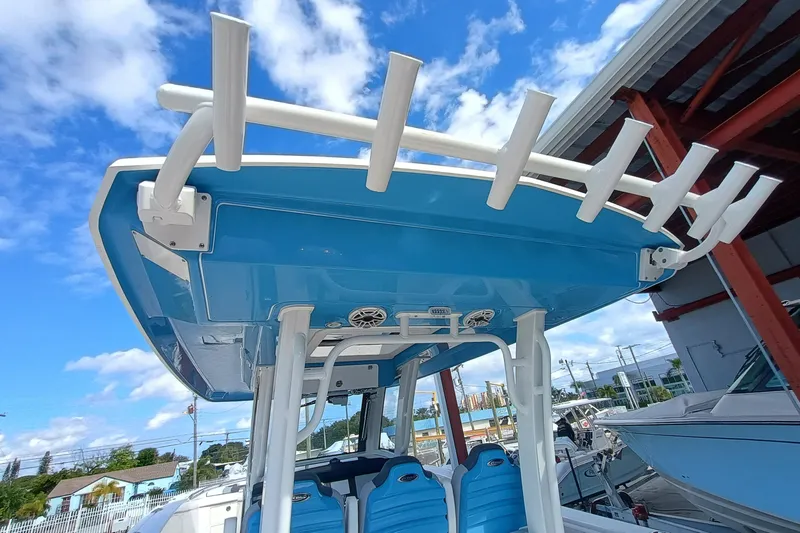 360-105 Yacht Photos Pics 2026 Robalo R360 Center Console boat with blue T-top and rod holders.