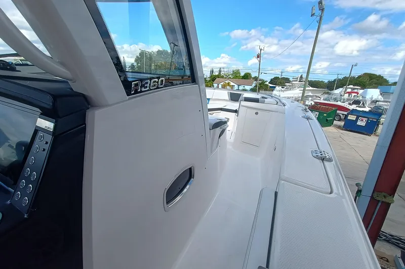 360-105 Yacht Photos Pics 2026 Robalo R360 Center Console boat, sleek design, docked under a clear blue sky.