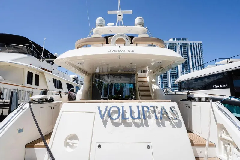 Voluptas Yacht Photos Pics Luxury 2006 Aicon Flybridge yacht docked, featuring "Voluptas" nameplate, with cityscape background.