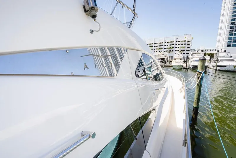 Voluptas Yacht Photos Pics 2006 Aicon Flybridge yacht docked at marina, reflecting cityscape in windows.