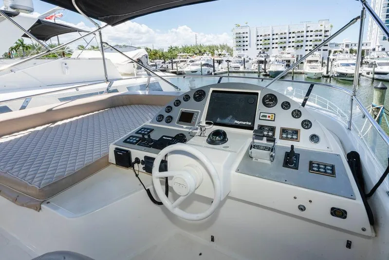 Voluptas Yacht Photos Pics 2006 Aicon Flybridge yacht helm with navigation controls and marina view.