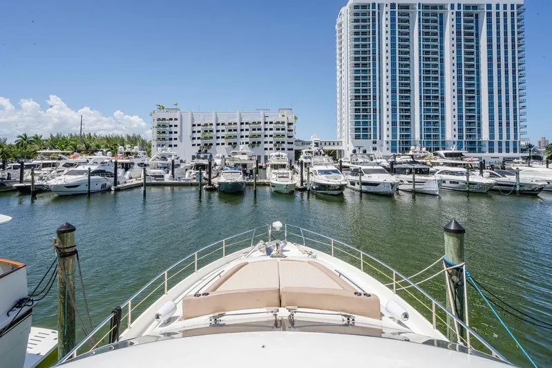 Voluptas Yacht Photos Pics Aicon Flybridge 2006 yacht docked in a marina with high-rise buildings in the background.