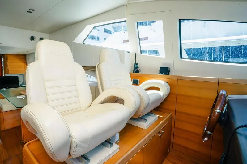 Voluptas Yacht Photos Pics Interior of 2006 Aicon Flybridge yacht with luxurious white leather seats and wooden accents.