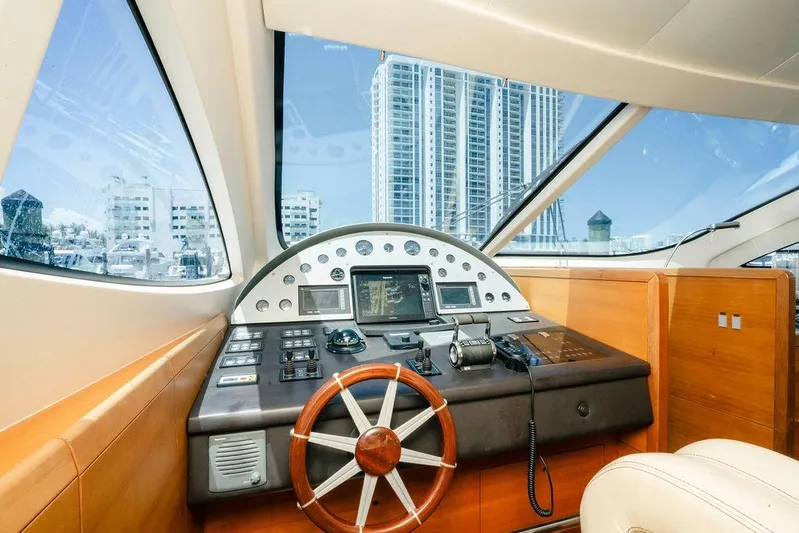 Voluptas Yacht Photos Pics Interior view of 2006 Aicon Flybridge yacht cockpit with cityscape background.