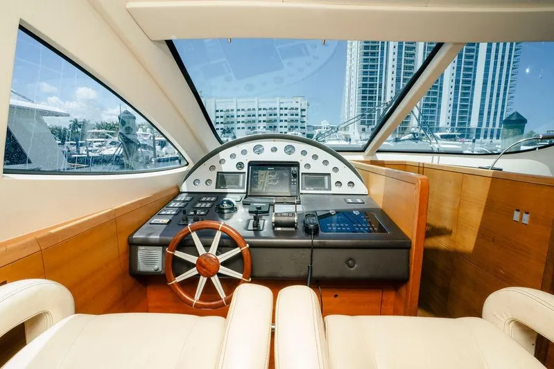 Voluptas Yacht Photos Pics Helm of 2006 Aicon Flybridge yacht with modern controls and cityscape view.