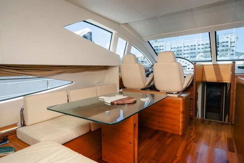 Voluptas Yacht Photos Pics Luxurious interior of 2006 Aicon Flybridge yacht with glass table and plush seating.