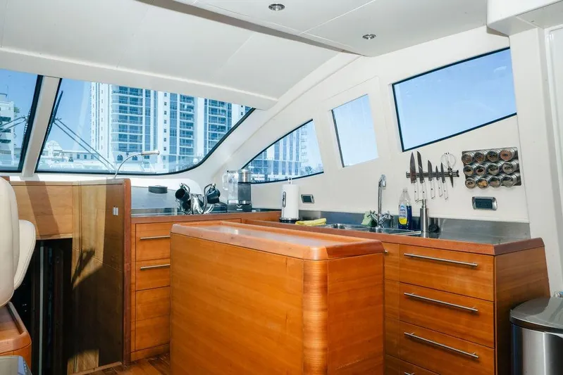 Voluptas Yacht Photos Pics Luxurious 2006 Aicon Flybridge yacht kitchen with wooden cabinetry and modern amenities.