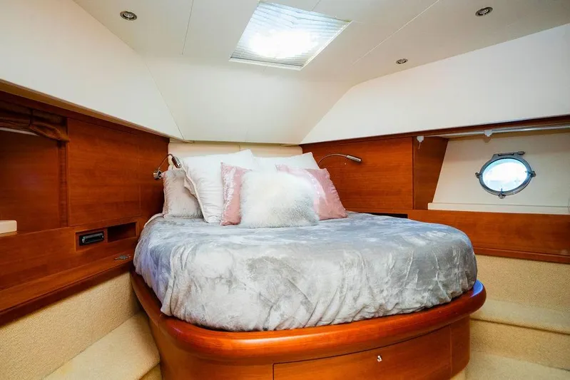 Voluptas Yacht Photos Pics Luxurious 2006 Aicon Flybridge yacht bedroom with cozy bedding and elegant wood finish.