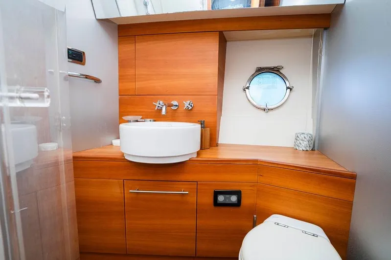 Voluptas Yacht Photos Pics Luxurious 2006 Aicon Flybridge yacht bathroom with wooden cabinetry and porthole window.