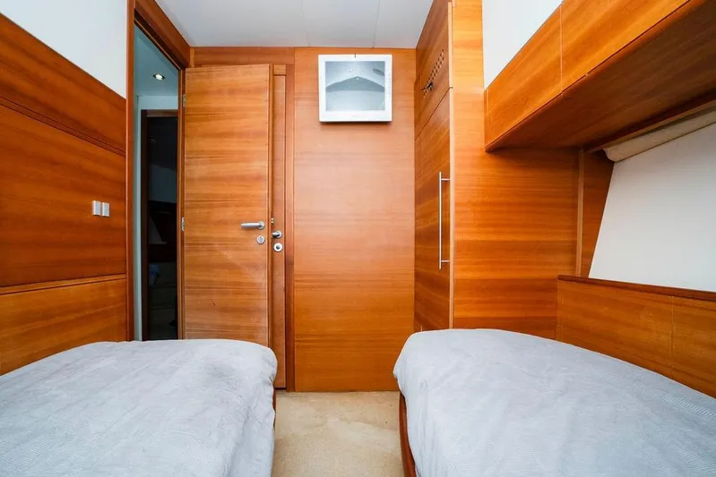 Voluptas Yacht Photos Pics Interior of 2006 Aicon Flybridge yacht cabin with twin beds and wooden paneling.