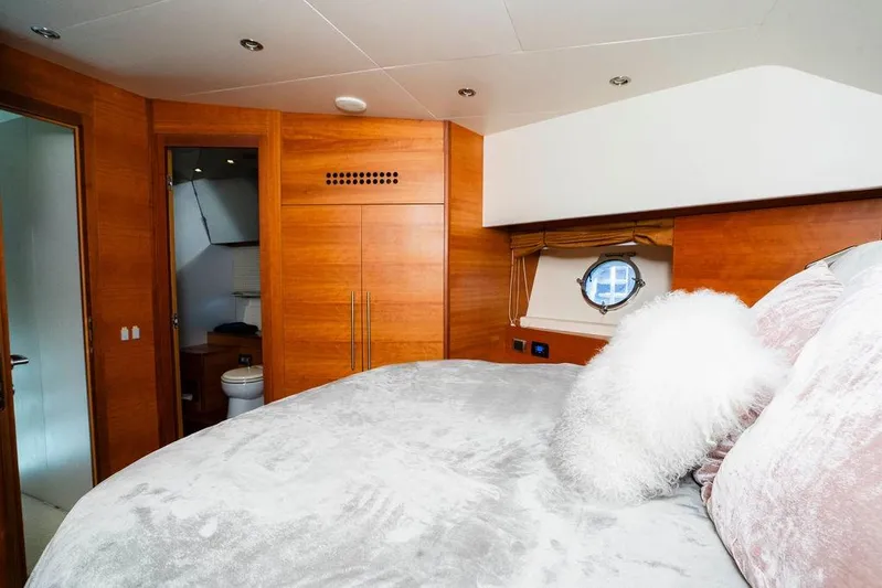Voluptas Yacht Photos Pics Luxurious 2006 Aicon Flybridge yacht bedroom with wood paneling and plush bedding.