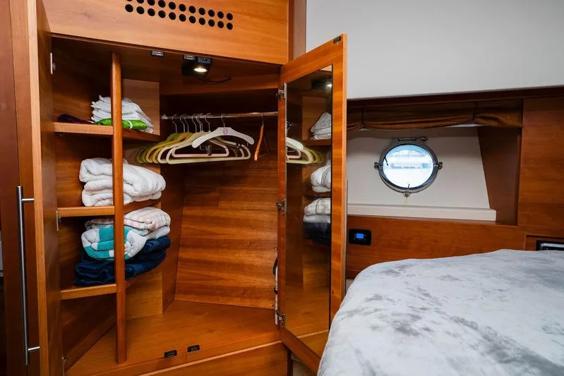 Voluptas Yacht Photos Pics Luxurious 2006 Aicon Flybridge yacht interior with wooden wardrobe and porthole view.