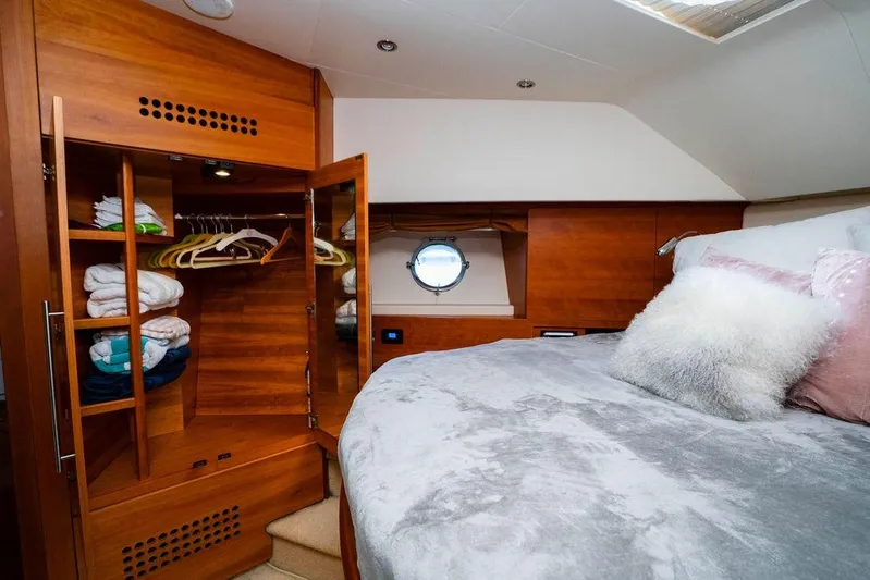 Voluptas Yacht Photos Pics Luxurious 2006 Aicon Flybridge yacht bedroom with wooden wardrobe and cozy bedding.