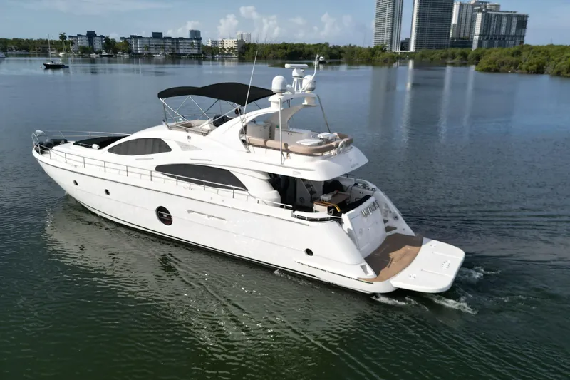 Voluptas Yacht Photos Pics Aicon Flybridge 2006 yacht cruising on calm waters near modern cityscape.