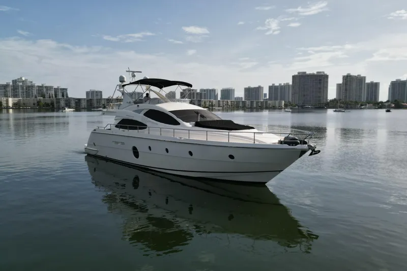 Voluptas Yacht Photos Pics Aicon Flybridge 2006 yacht on calm water with city skyline background.