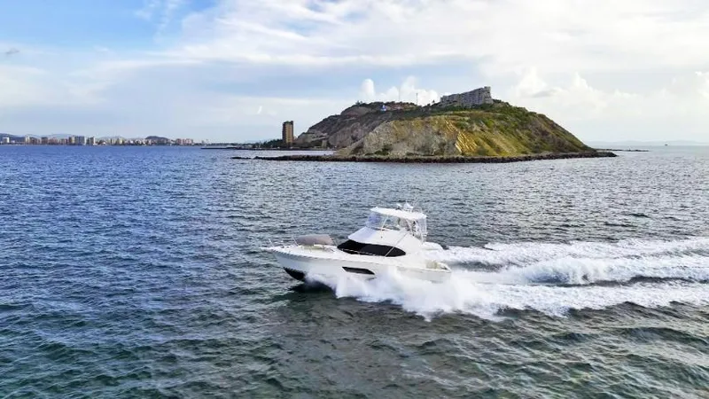  Yacht Photos Pics 2012 Riviera Convertible yacht cruising near a scenic island.