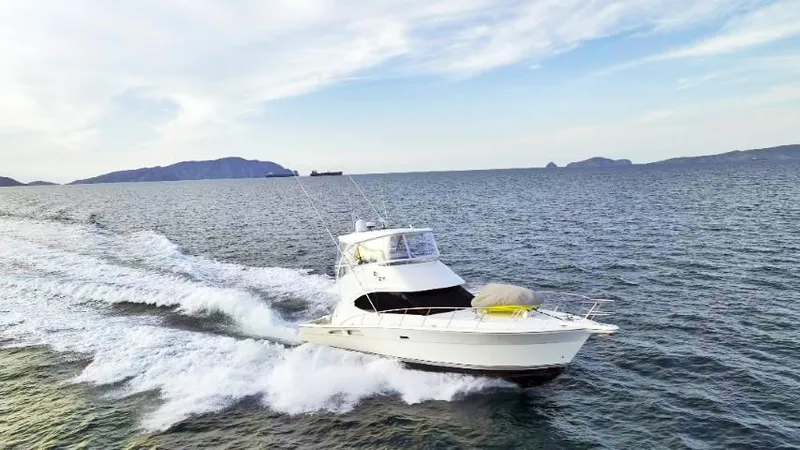  Yacht Photos Pics 2012 Riviera Convertible yacht cruising on open water with scenic island backdrop.