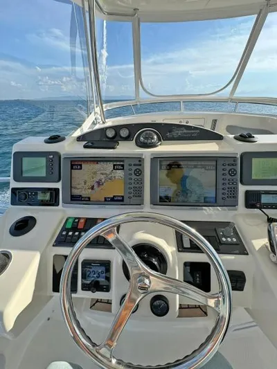  Yacht Photos Pics 2012 Riviera Convertible yacht helm with navigation screens and steering wheel on open sea.