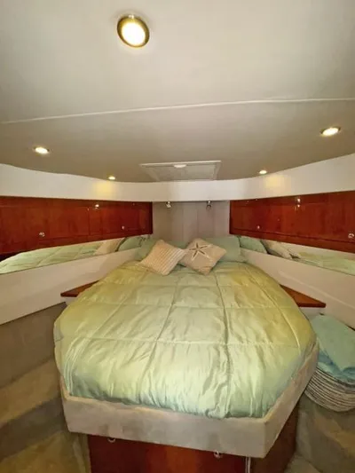  Yacht Photos Pics Luxurious 2012 Riviera Convertible yacht bedroom with cozy bedding and elegant wood cabinetry.
