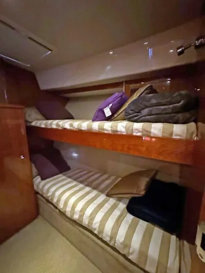  Yacht Photos Pics 2012 Riviera Convertible yacht bunk beds with striped bedding and cushions.