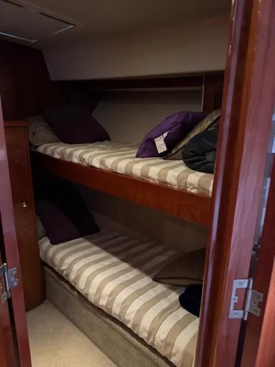  Yacht Photos Pics 2012 Riviera Convertible yacht interior with cozy bunk beds and striped bedding.