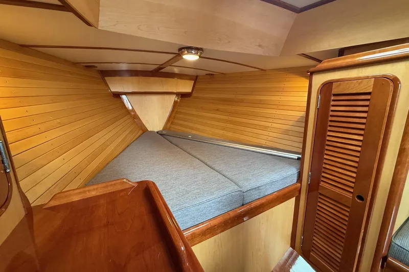 Sea Suite Yacht Photos Pics Cozy cabin interior of 2015 Hinckley DS 42 with wooden paneling and cushioned bed.