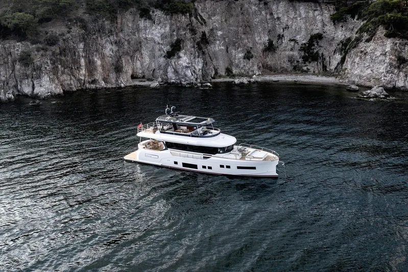  Yacht Photos Pics Luxurious 2024 Sirena 68 yacht cruising near rocky coastline.