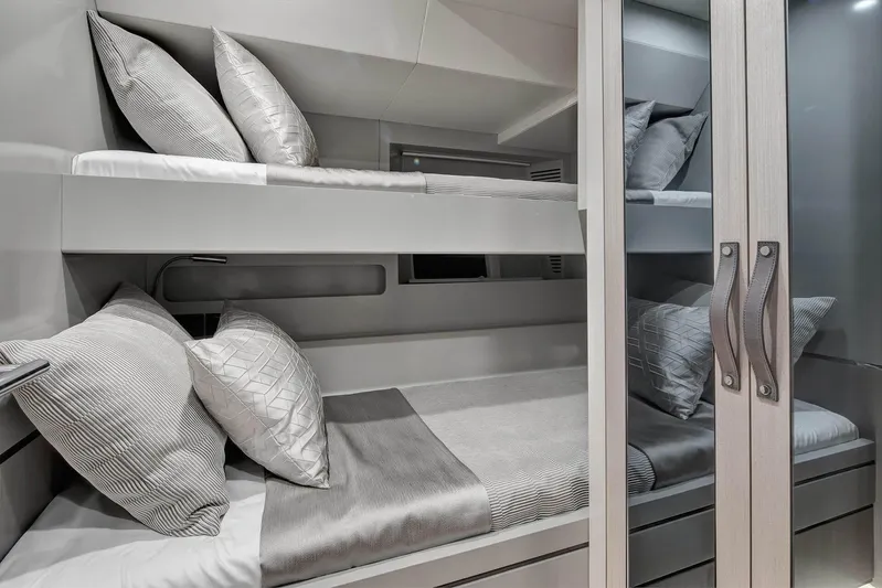  Yacht Photos Pics Luxurious bunk beds in 2024 Sirena 68 yacht cabin, featuring elegant bedding and modern design.