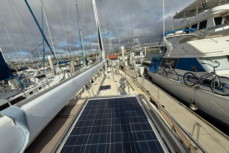 Sarah Yacht Photos Pics Cabo Rico Cutter 45 sailboat docked, featuring solar panels, surrounded by other boats.