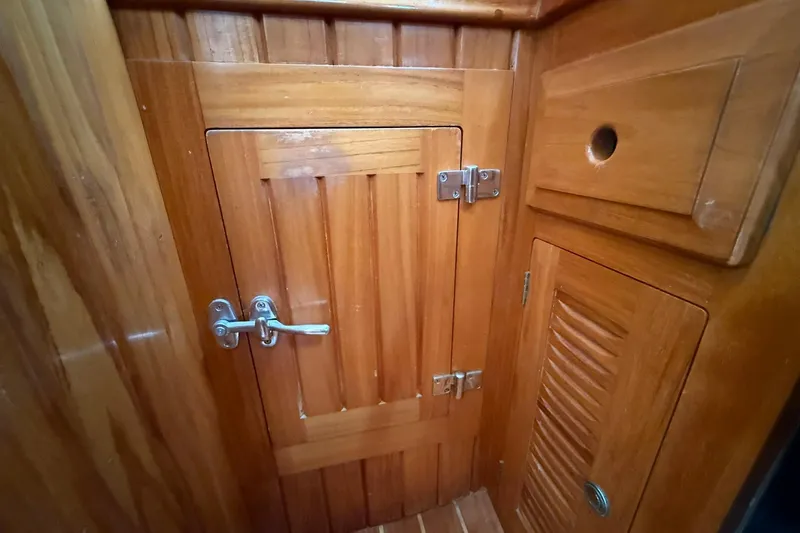 Sarah Yacht Photos Pics Wooden interior of 2000 Cabo Rico Cutter 45 sailboat, featuring cabinets and door.