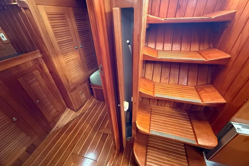 Sarah Yacht Photos Pics Interior of 2000 Cabo Rico Cutter 45, featuring wooden stairs and cabinetry.