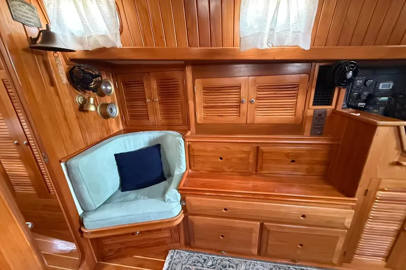 Sarah Yacht Photos Pics Interior of 2000 Cabo Rico Cutter 45 with wooden cabinetry and cozy seating area.