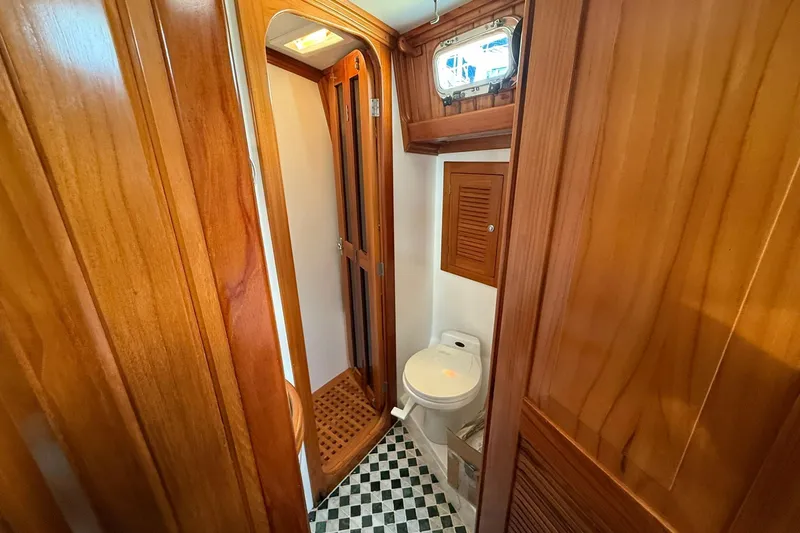Sarah Yacht Photos Pics Cabo Rico Cutter 45 (2000) yacht bathroom with wooden interior and checkered floor.