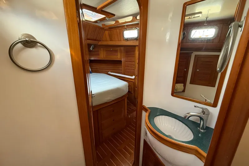 Sarah Yacht Photos Pics Cabo Rico Cutter 45 yacht interior, featuring a cozy cabin and elegant bathroom, 2000 model.