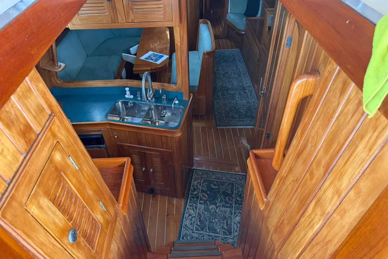 Sarah Yacht Photos Pics Interior of 2000 Cabo Rico Cutter 45 sailboat with wooden cabinetry and compact kitchen.