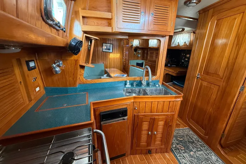 Sarah Yacht Photos Pics Luxurious 2000 Cabo Rico Cutter 45 yacht interior with wooden cabinetry and modern kitchen amenities.