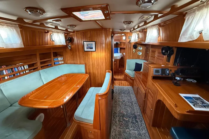 Sarah Yacht Photos Pics Interior of 2000 Cabo Rico Cutter 45 sailboat with wood paneling and cozy seating area.