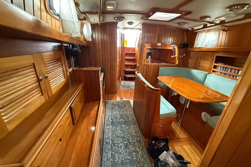 Sarah Yacht Photos Pics Luxurious interior of a 2000 Cabo Rico Cutter 45 sailboat with wood paneling and cozy seating.