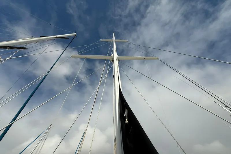 Sarah Yacht Photos Pics Mast and rigging of 2000 Cabo Rico Cutter 45 sailboat against cloudy sky.