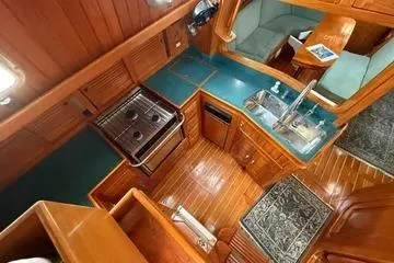 Sarah Yacht Photos Pics Interior of 2000 Cabo Rico Cutter 45 yacht with wooden cabinetry and compact kitchen.