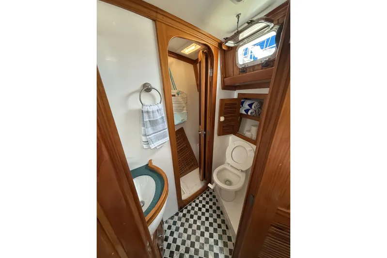 Sarah Yacht Photos Pics Cabo Rico Cutter 45 (2000) yacht bathroom with wooden accents and checkered floor.