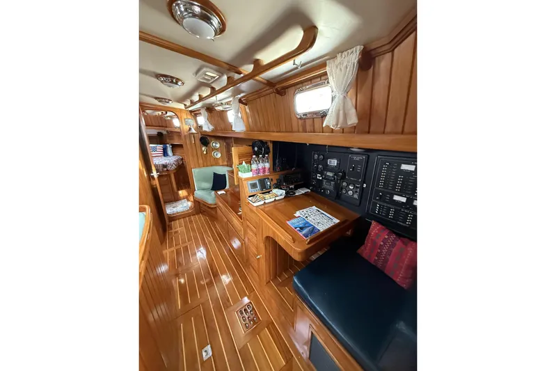 Sarah Yacht Photos Pics Luxurious interior of 2000 Cabo Rico Cutter 45 sailboat with wood paneling and navigation station.