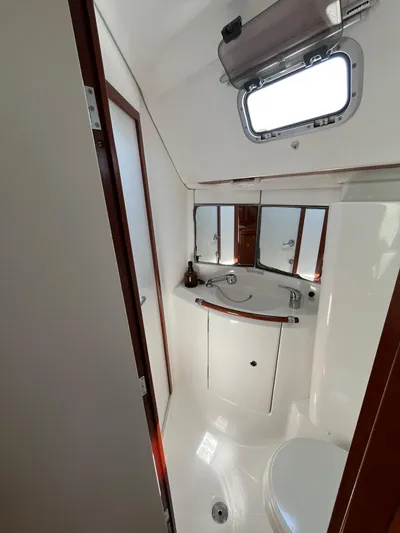  Yacht Photos Pics 2007 Beneteau 423 yacht bathroom with sink, mirror, and porthole window.