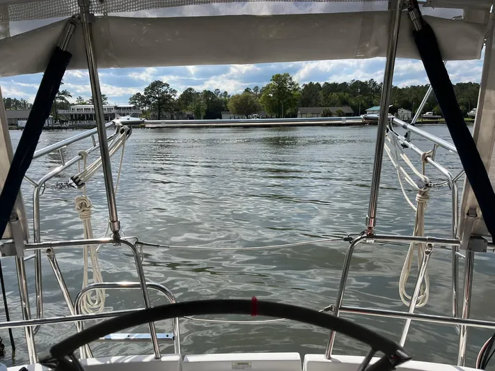  Yacht Photos Pics Cockpit view from a 2007 Beneteau 423 sailboat overlooking calm waters and distant shoreline.