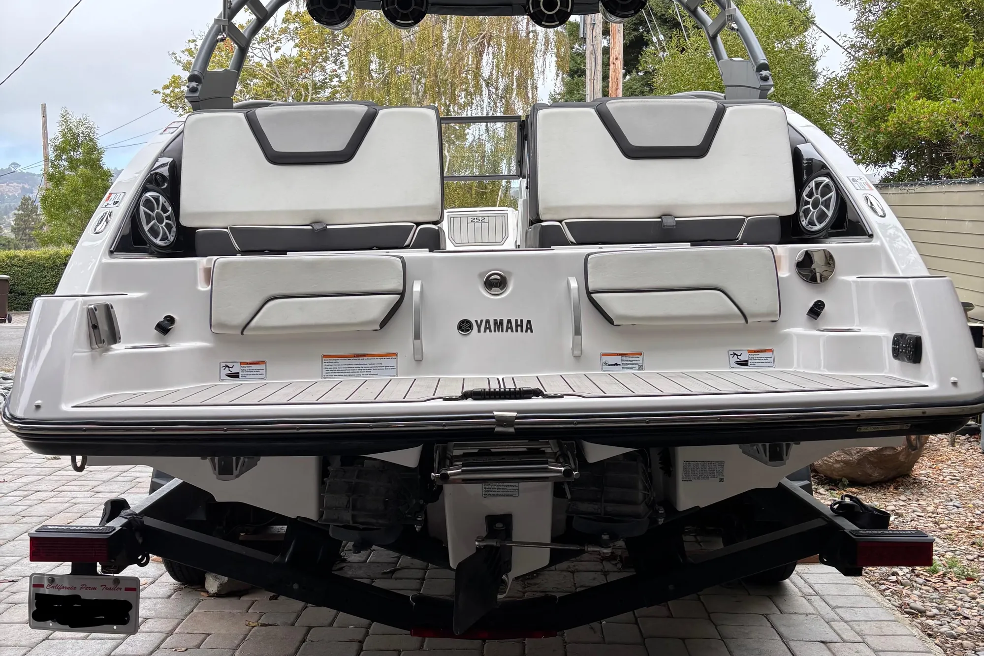 2022 Yamaha Boats 252S rear view, showcasing seating and speakers on a trailer.