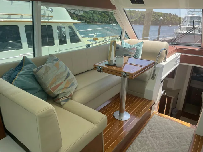 Seaquell Yacht Photos Pics Luxurious interior of 2012 Cruisers Yachts 48 Cantius with elegant seating and table.