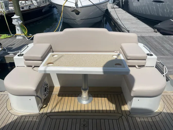 Seaquell Yacht Photos Pics 2012 Cruisers Yachts 48 Cantius deck with beige seating and table, docked at marina.