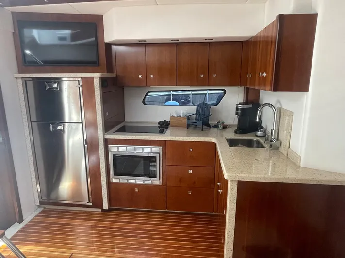Seaquell Yacht Photos Pics Luxurious 2012 Cruisers Yachts 48 Cantius kitchen with modern appliances and wood cabinetry.