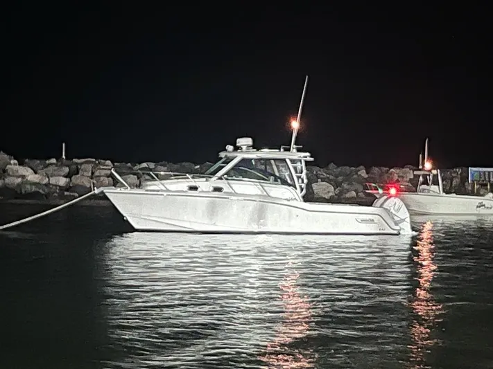 Yacht Photos Pics 2016 Boston Whaler 315 Conquest boat docked at night near rocky shore.
