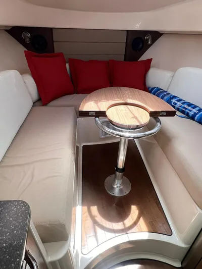  Yacht Photos Pics 2016 Boston Whaler 315 Conquest cabin with table, seating, and red cushions.